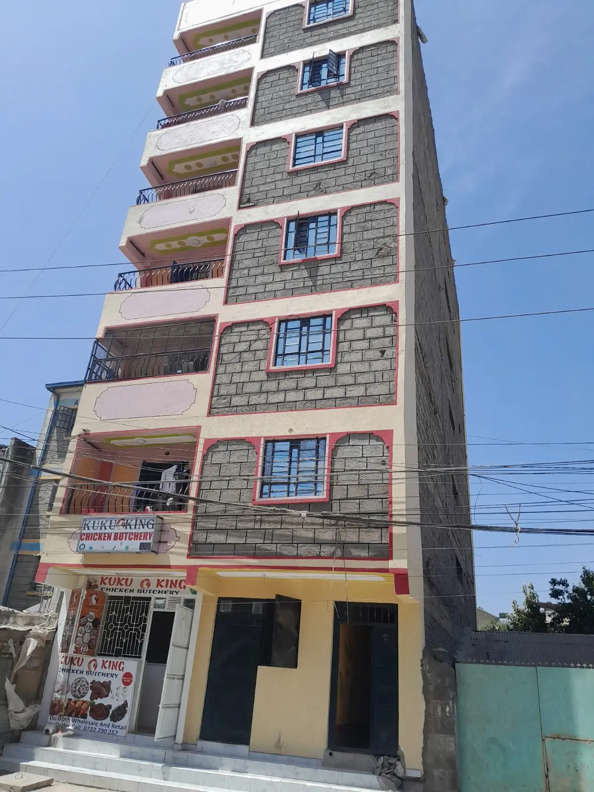 Multi-story residential building facade with balconies and ground floor commercial