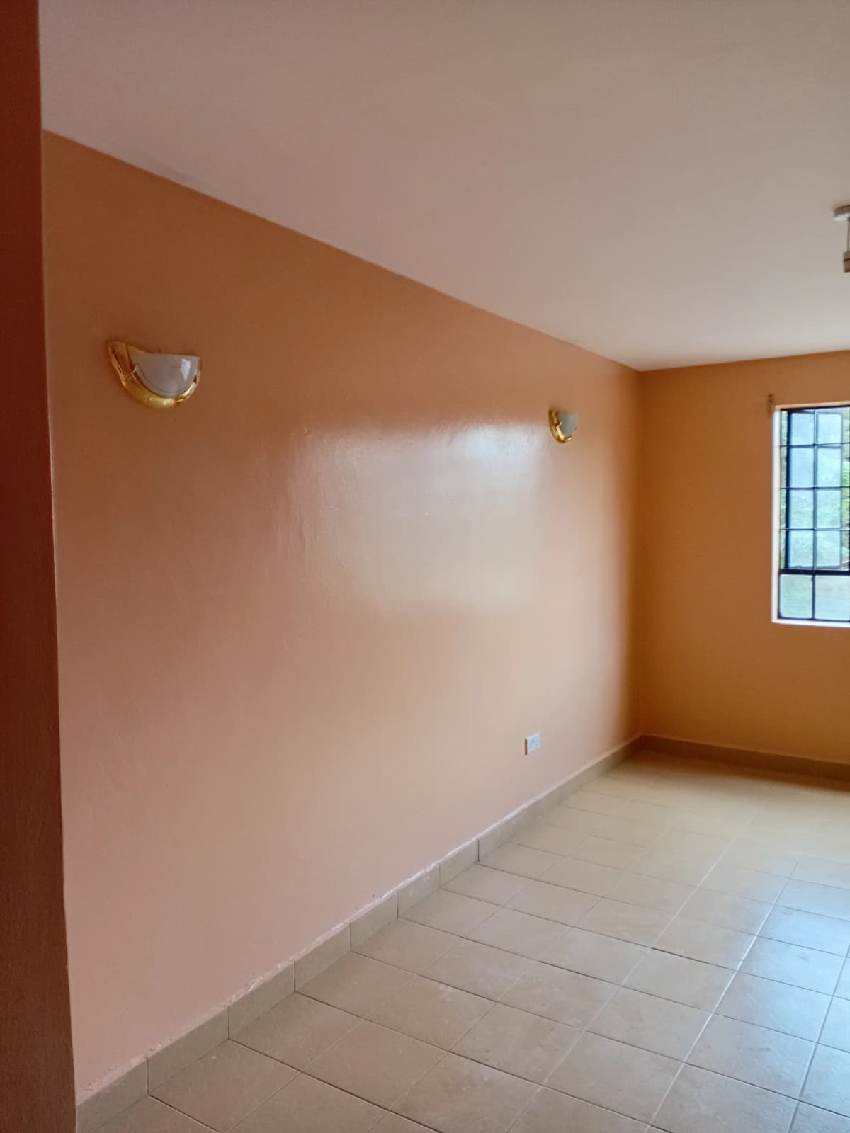 Unfurnished bedroom with peach walls and tiled floor