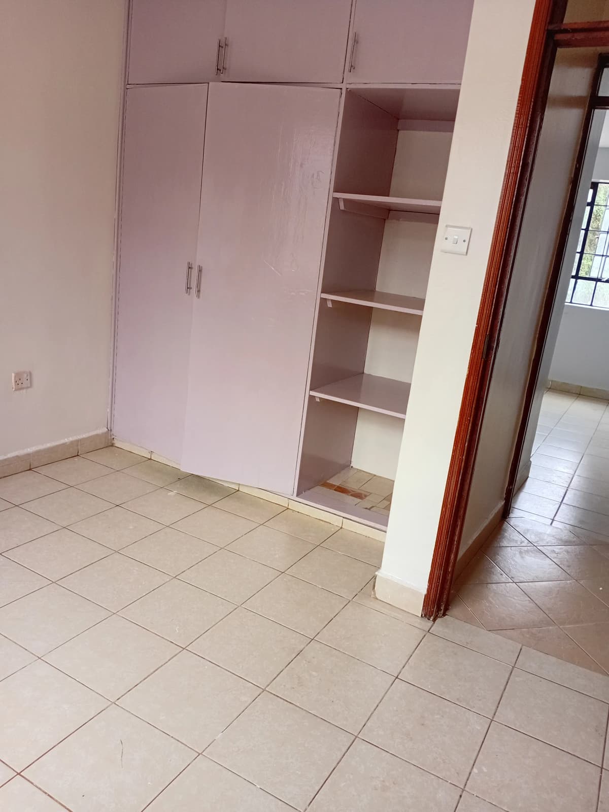 Unfurnished bedroom with built-in wardrobe and open shelving