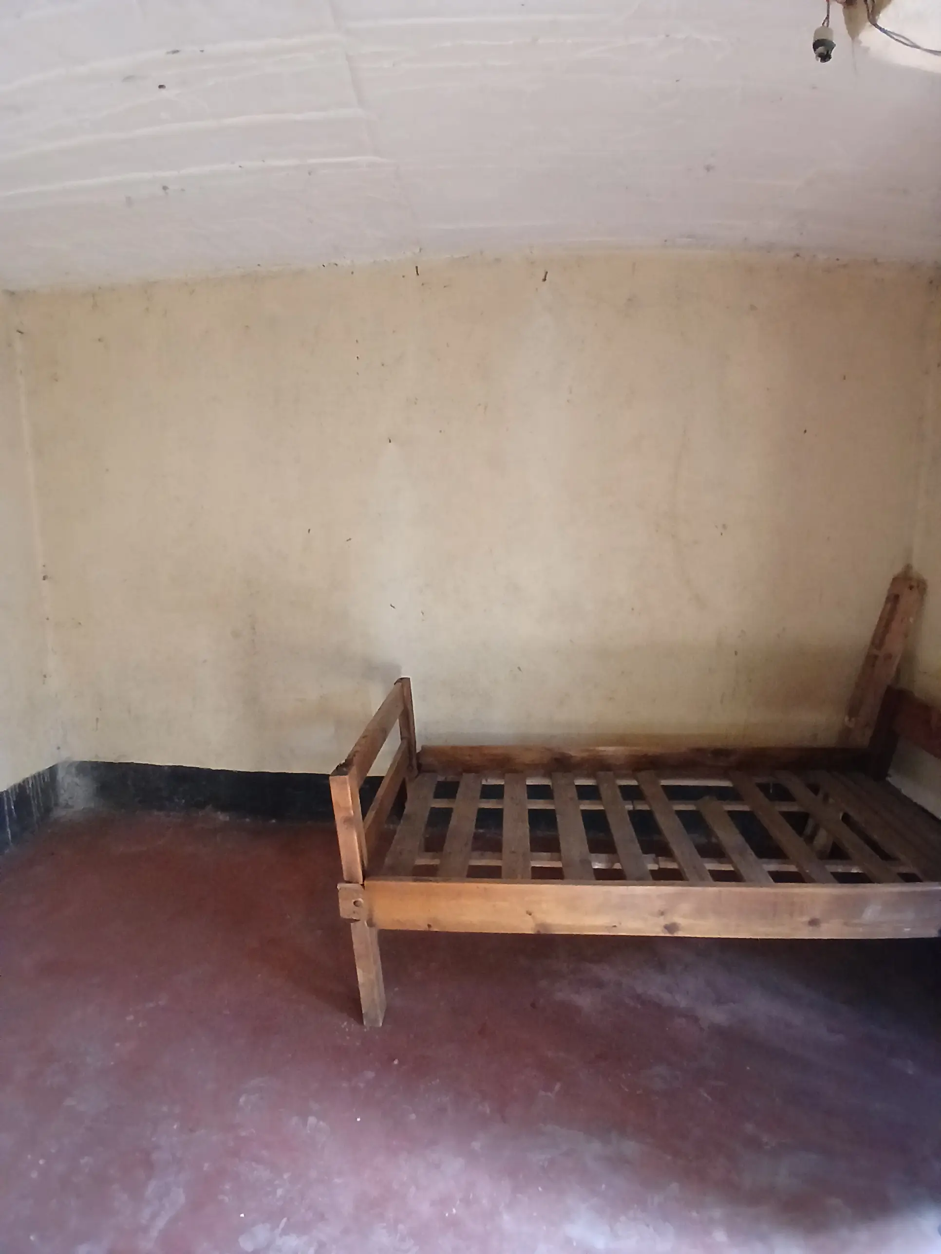 Sparse bedroom with single bed frame, unfurnished