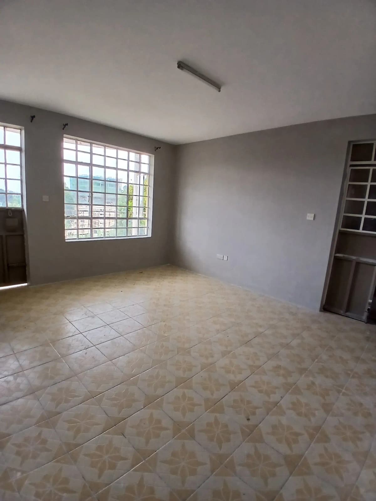Spacious living room with tiled floors and natural light