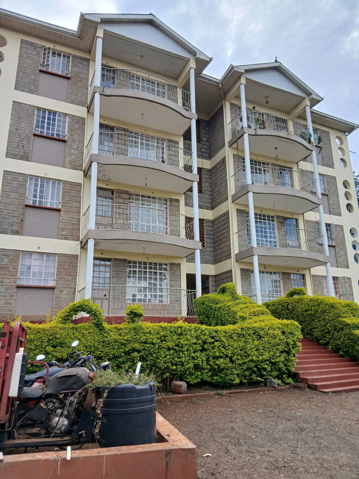 Multi-story residential building with balconies and landscaped grounds