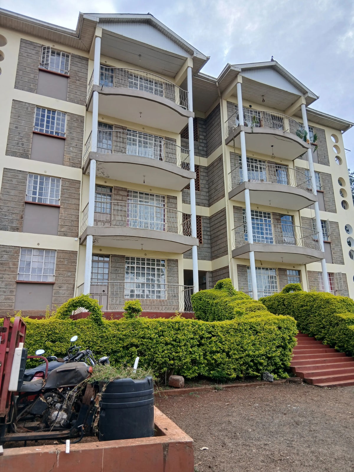 Multi-story residential building with balconies and landscaped grounds