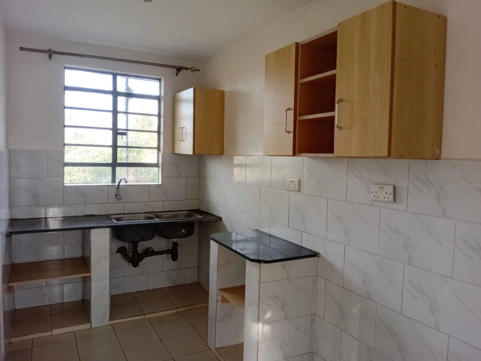 Compact kitchen with wooden cabinets, black countertop, stove