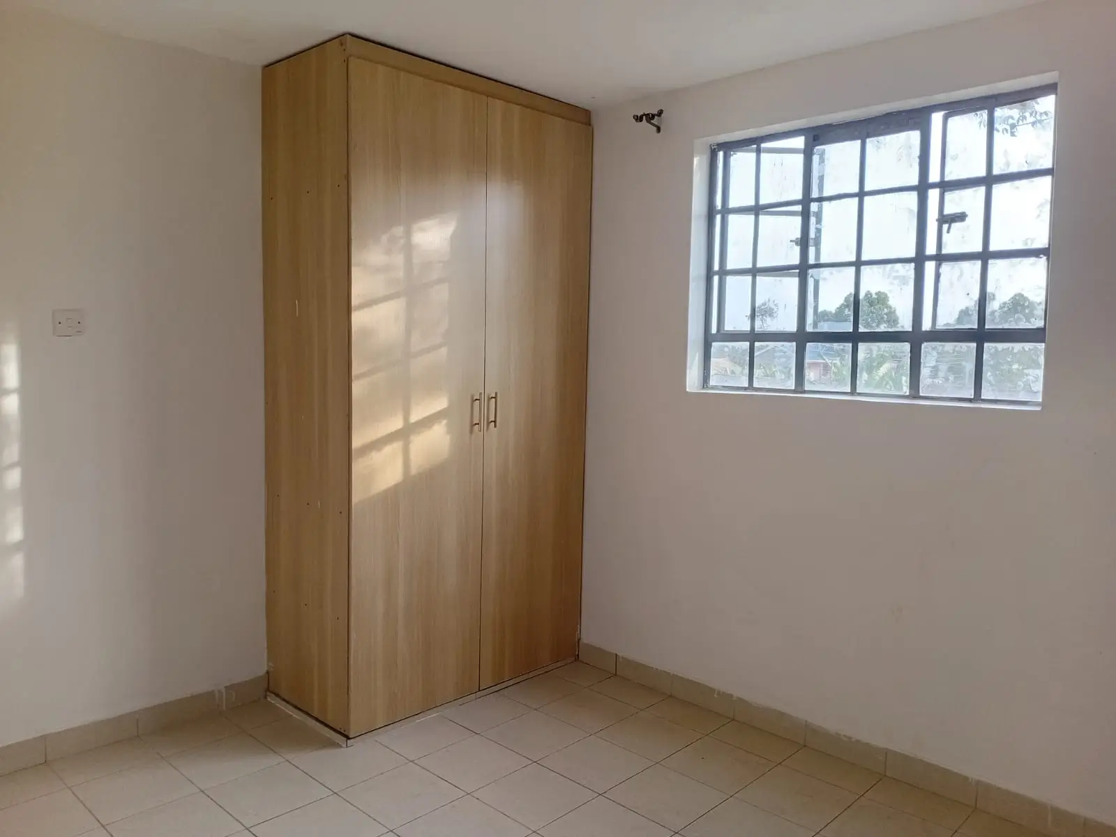 Bright bedroom with wooden wardrobe and large window