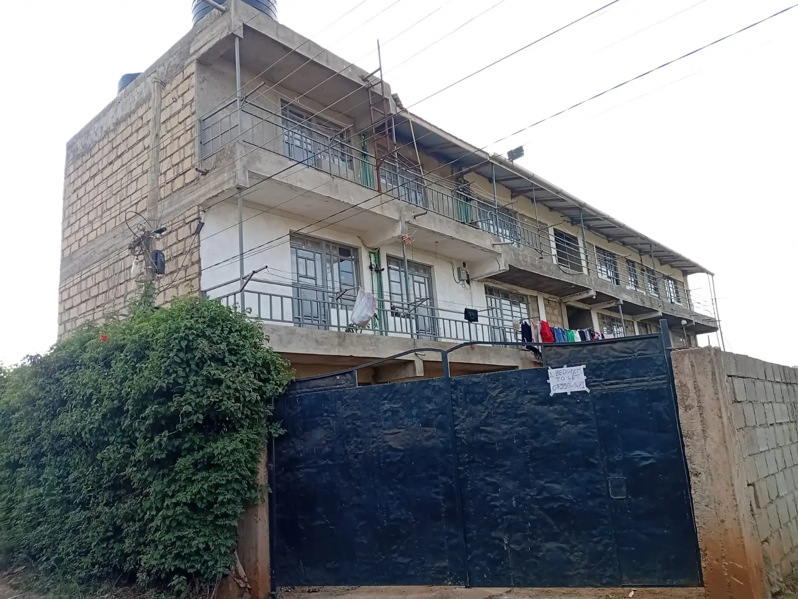 Multi-story residential building with blue metal gate entrance