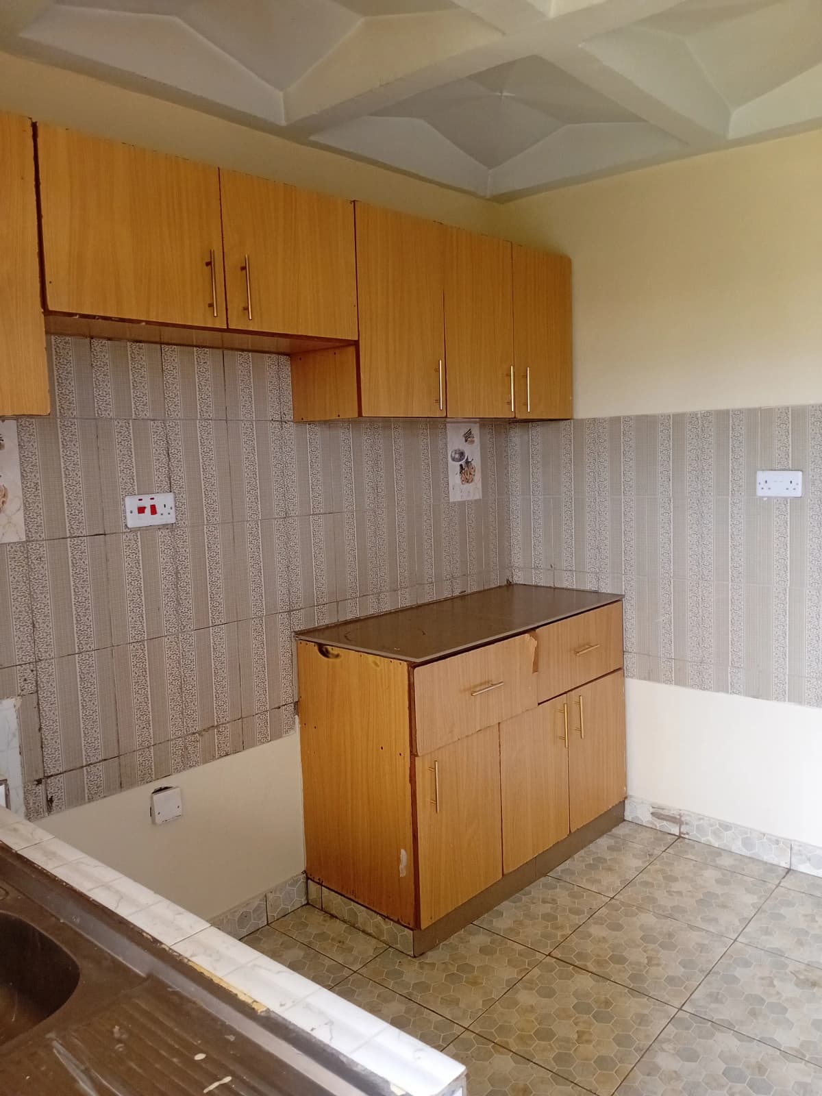 Compact kitchen with wooden cabinets and tile backsplash