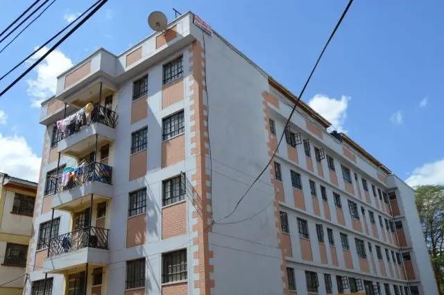 Multi-story residential building facade with balconies and brick detailing