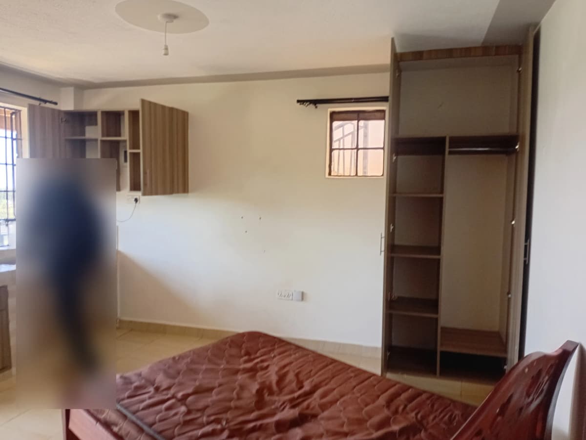 Spacious bedroom with built-in wooden wardrobes and natural light