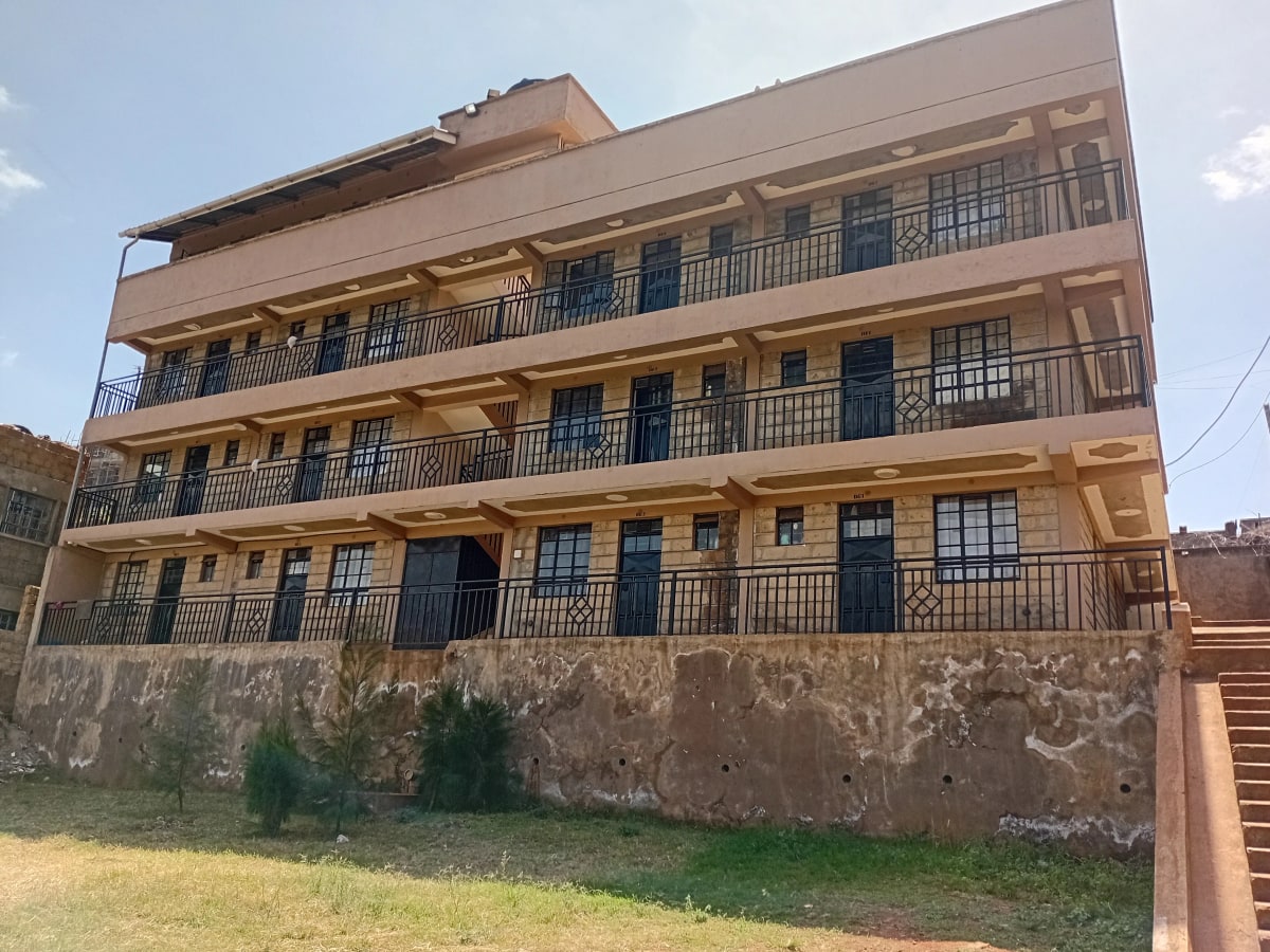 Multi-story residential building with balconies and manicured grounds