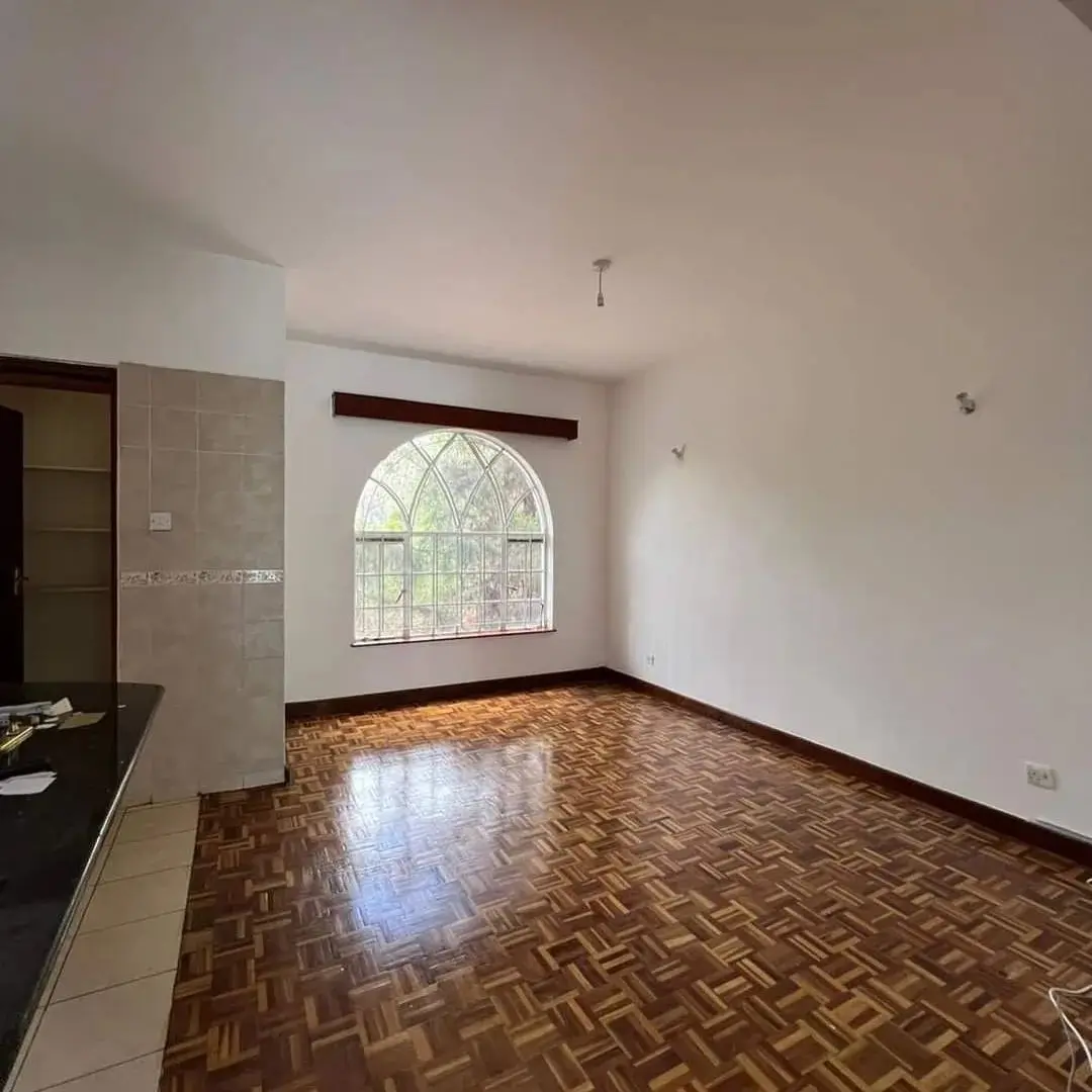 Open-plan living area with herringbone flooring and arched window