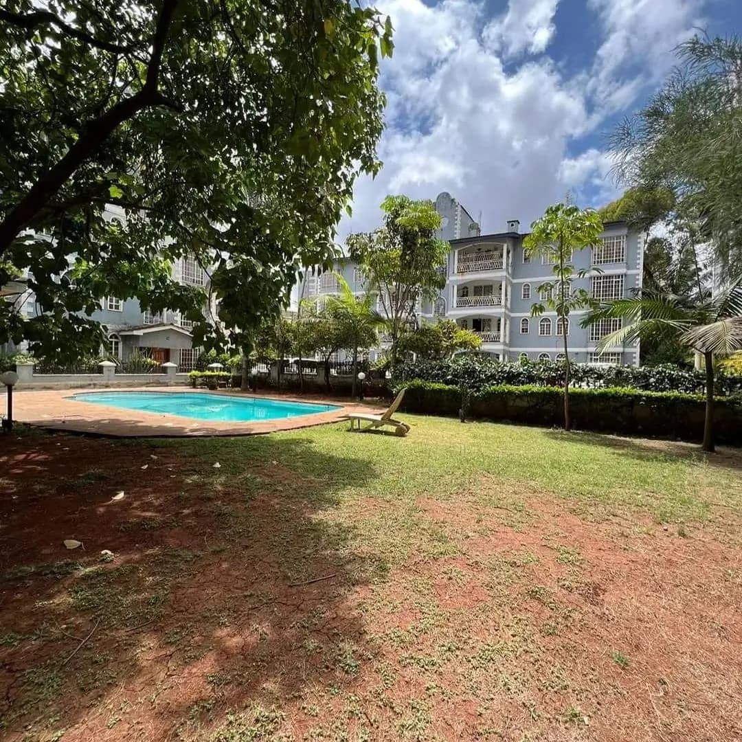 Swimming pool in landscaped compound with mature trees