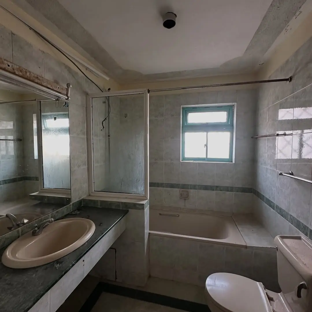 Spacious bathroom with round sink, glass shower enclosure, toilet
