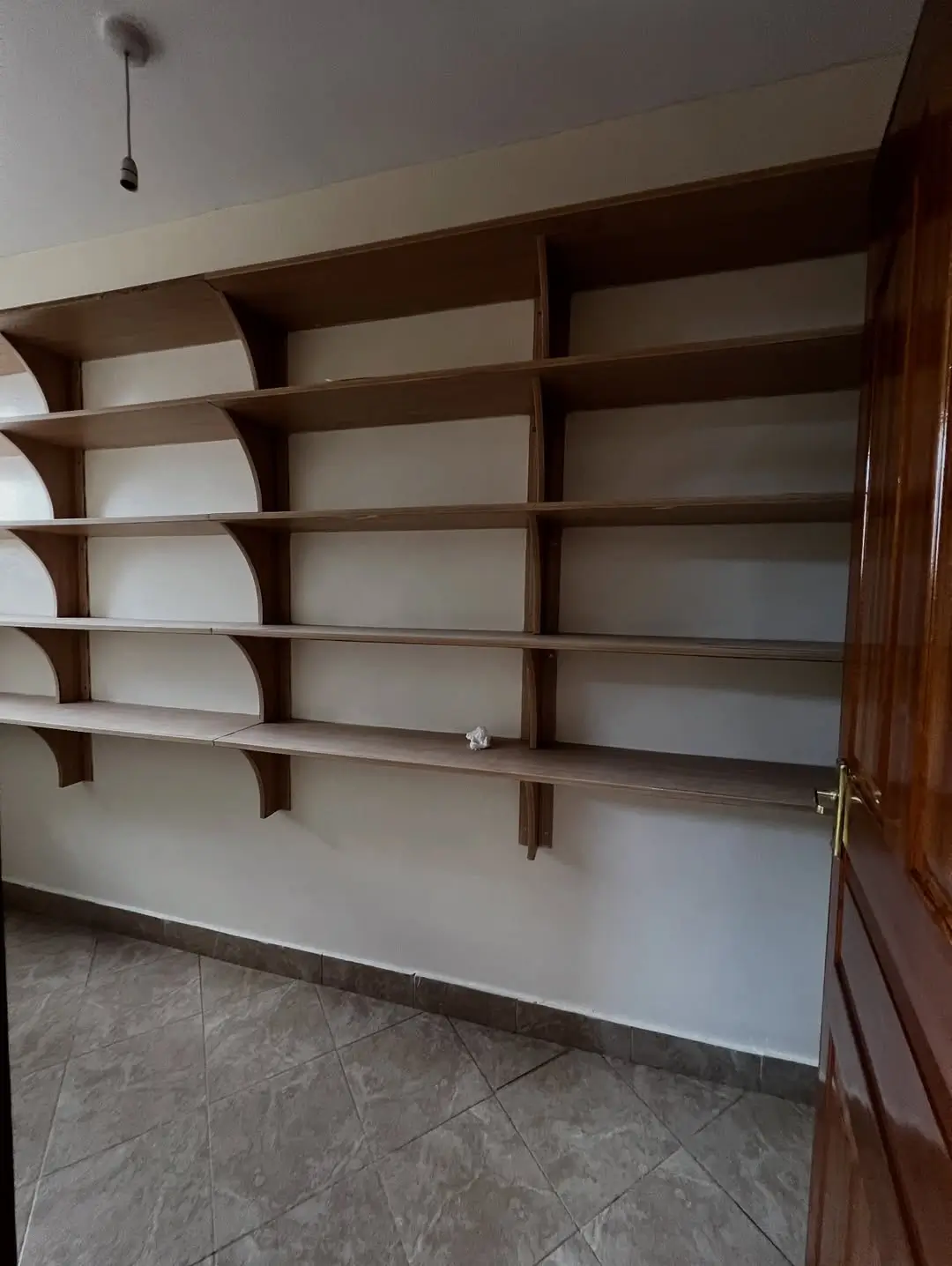 Empty wooden shelving unit with multiple compartments, newly installed