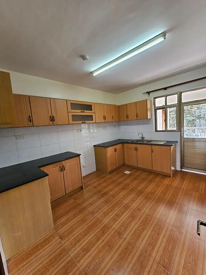 Spacious kitchen with wooden cabinets and black countertops