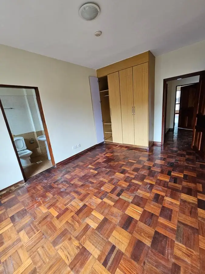 Spacious bedroom with wooden wardrobe and parquet flooring