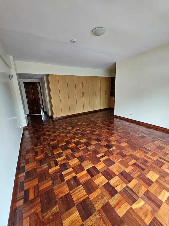Spacious bedroom with wooden wardrobe and parquet flooring
