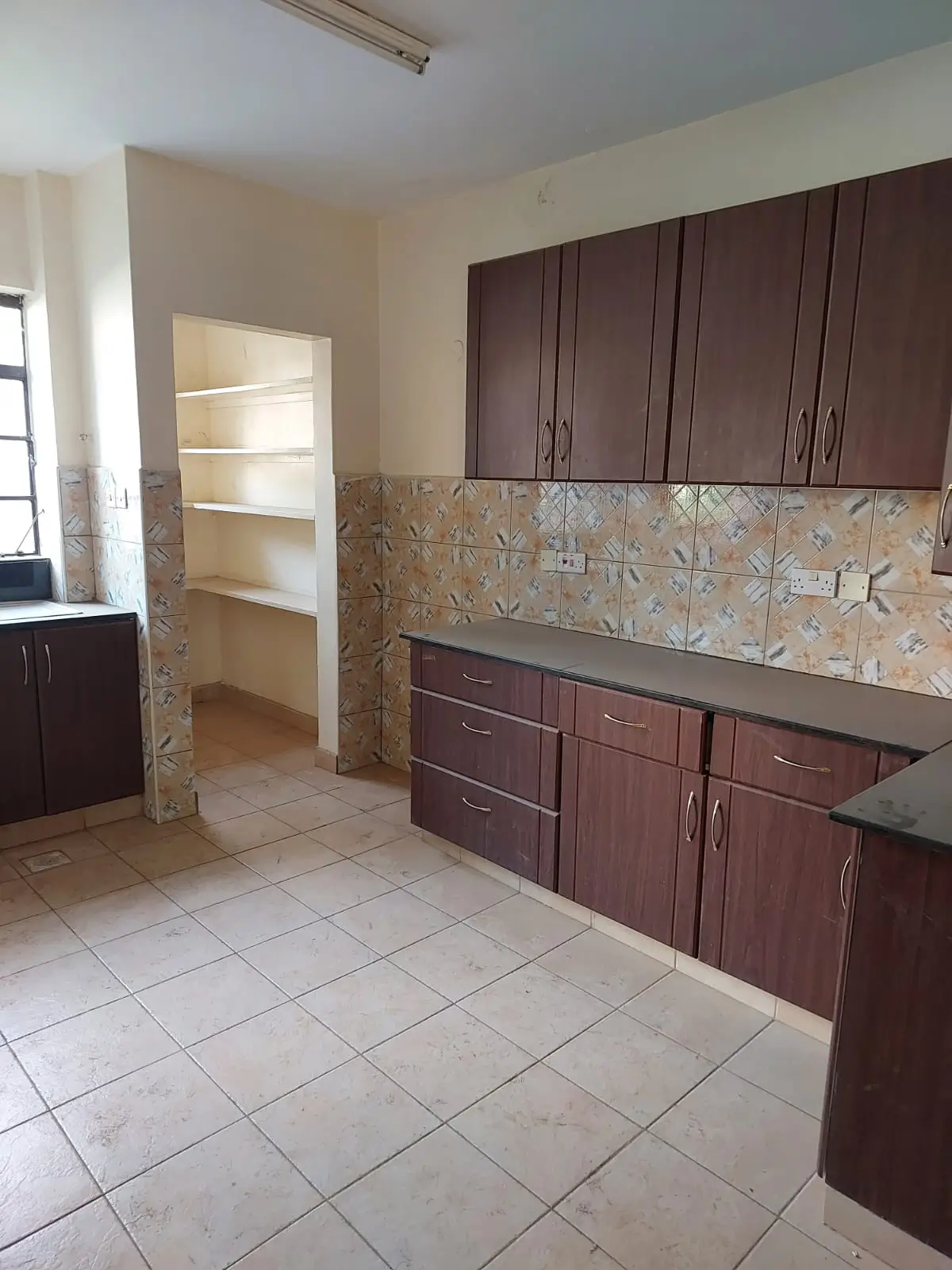 Kitchen with dark cabinetry, tile backsplash, open shelving pantry