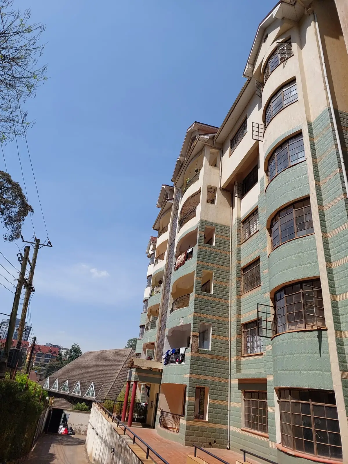 Multi-story residential building facade with green stone cladding