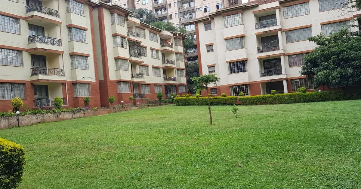Large manicured lawn with residential apartment buildings backdrop