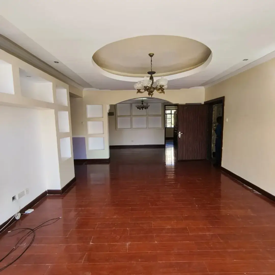 Spacious open-plan lounge with decorative ceiling and wooden floors