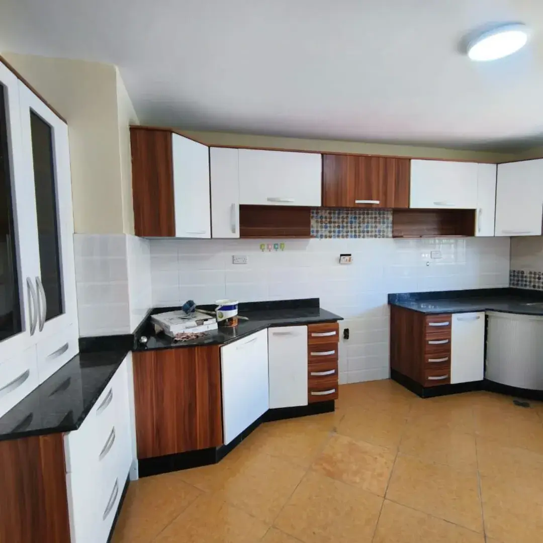 Modern kitchen with wood and white cabinetry, black countertops