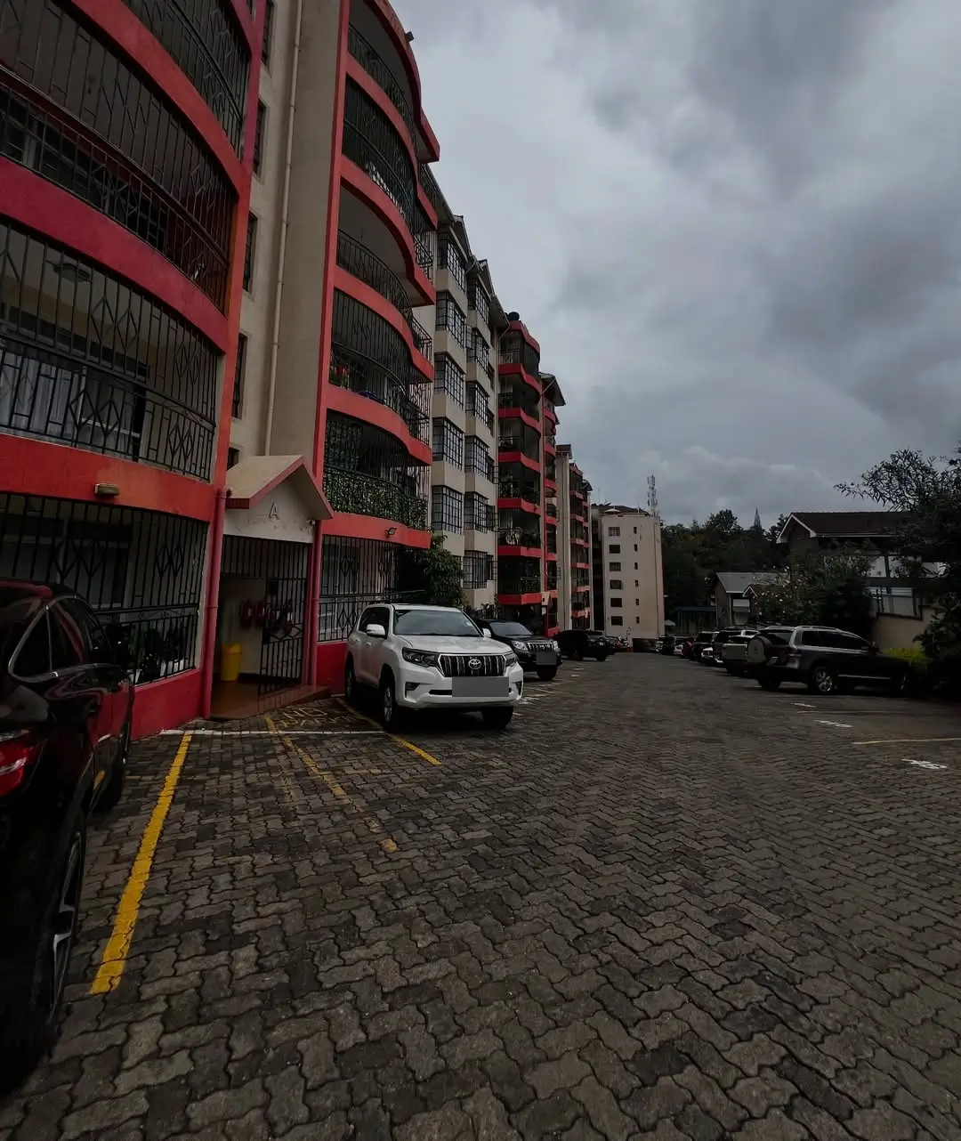 Ground-level parking area with multi-story residential building facade