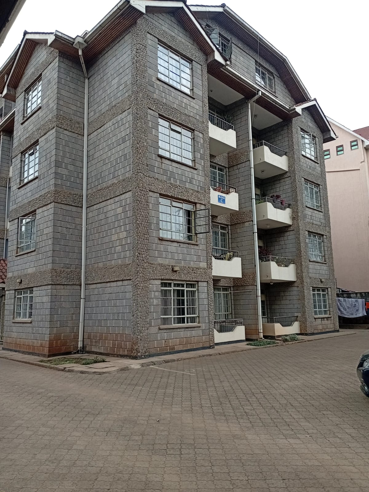 Modern multi-story residential building with stone facade and balconies