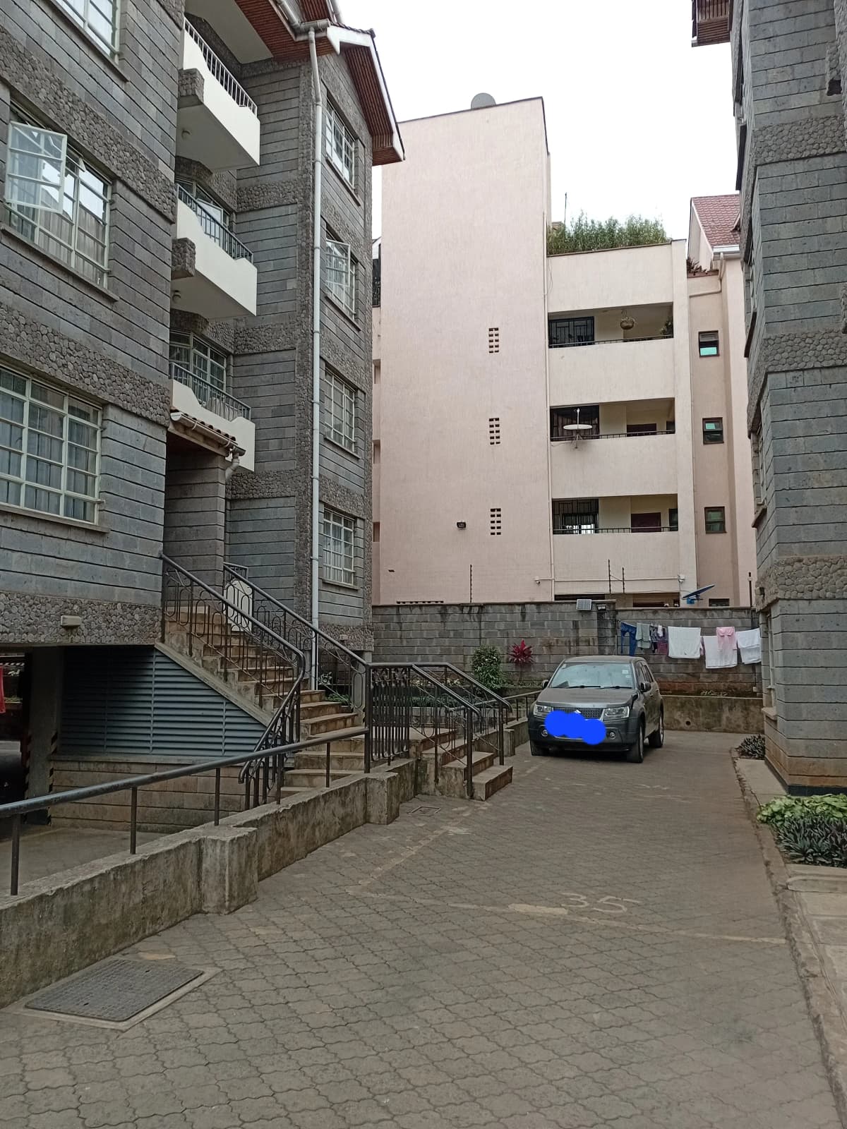 Multi-story residential compound with shared courtyard and parking area