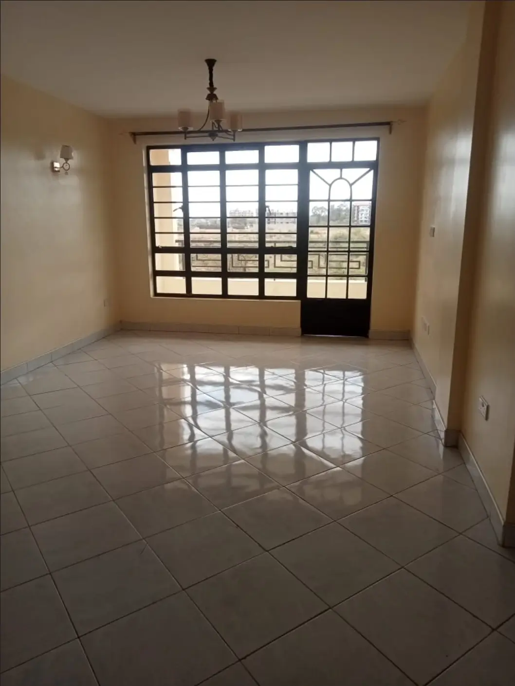 Spacious living room with polished tile floors and large windows