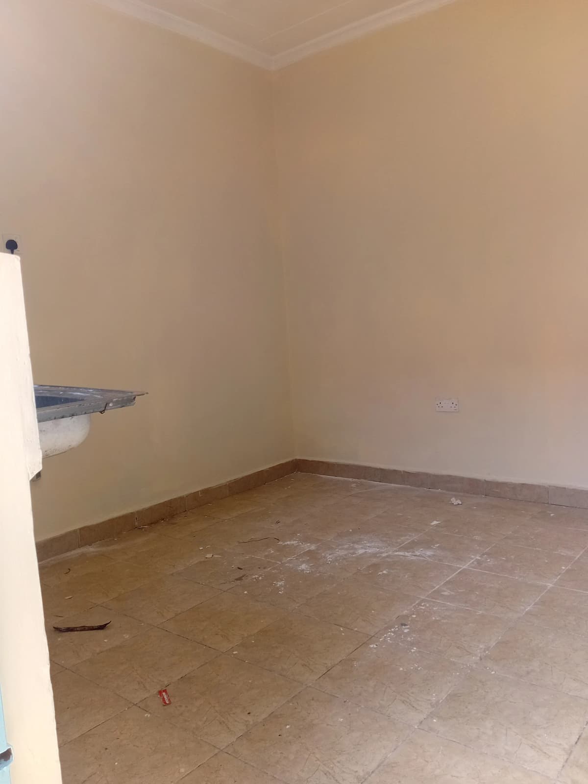 Empty bedroom with tiled floor and plain walls