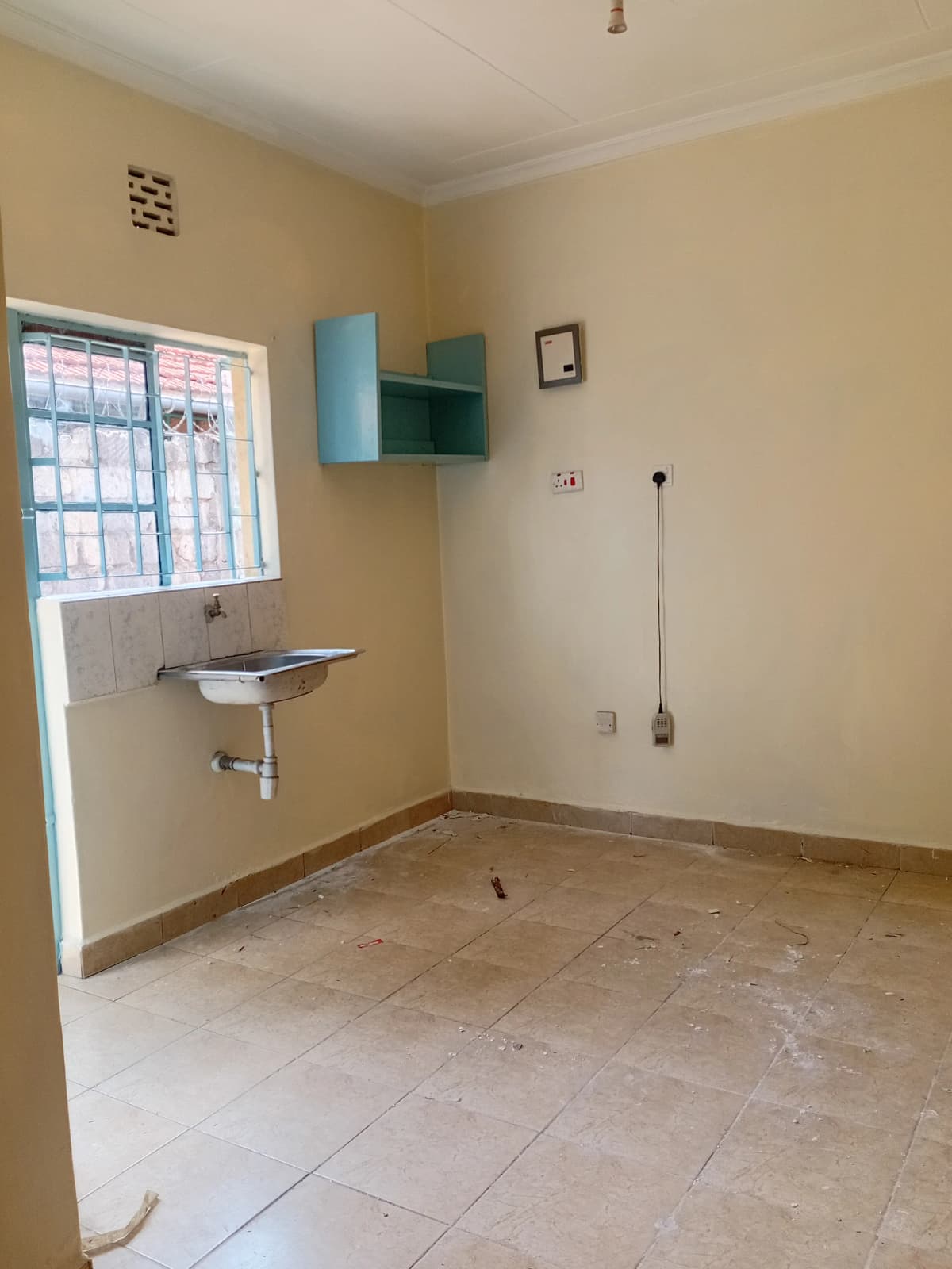 Compact kitchen with wall-mounted sink and storage cabinet