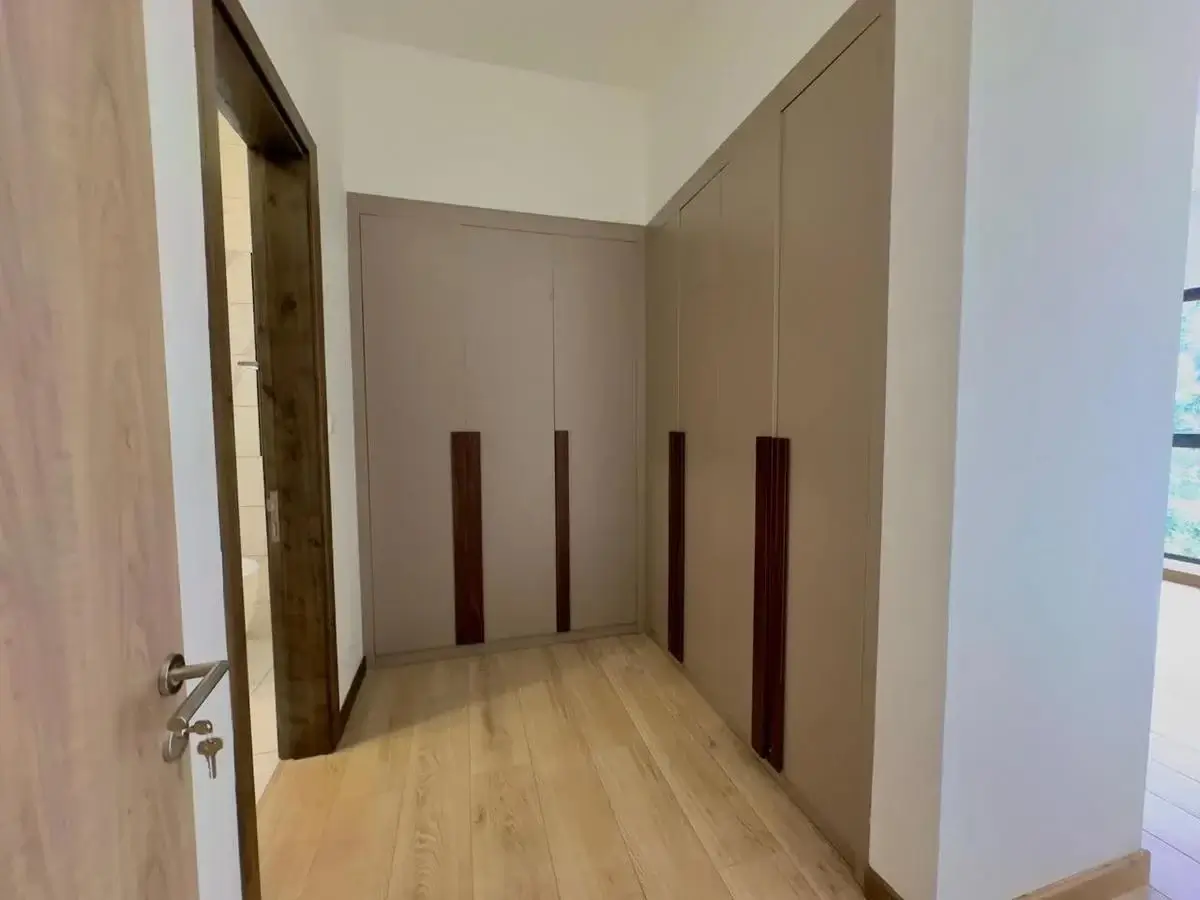 Corridor with built-in wardrobes and wooden flooring