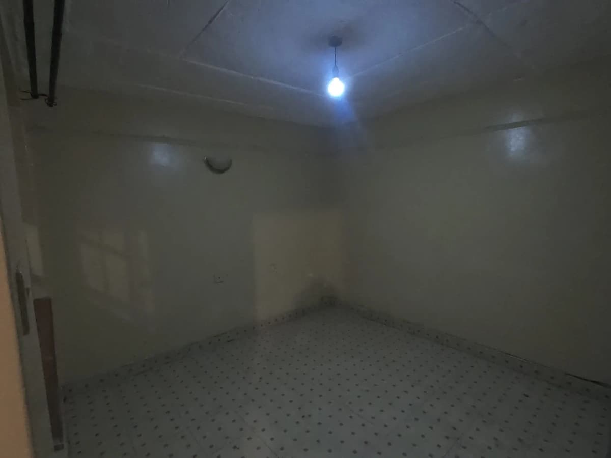 Empty room with concrete floor and single ceiling light