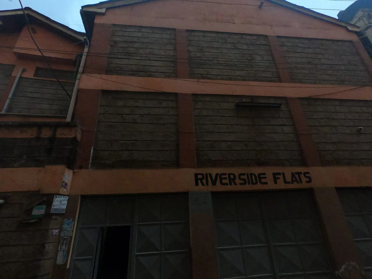 Red brick apartment building facade with Riverside Flats signage
