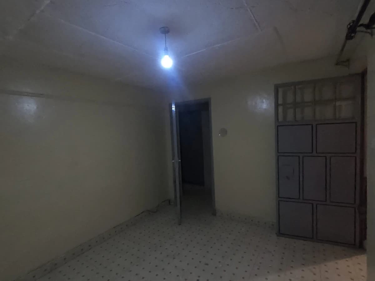 Empty corridor with overhead lighting and storage cupboards