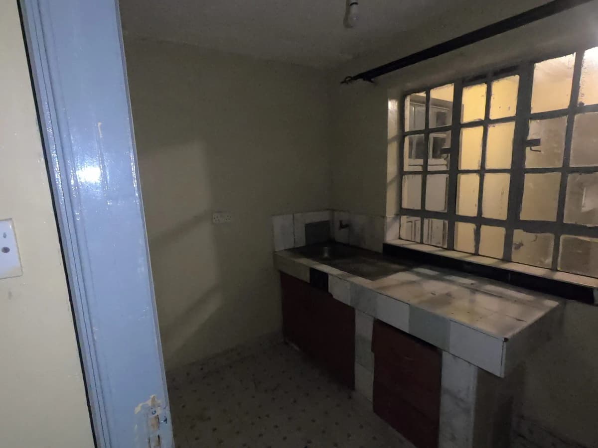 Unfurnished kitchen with countertops and gridded window