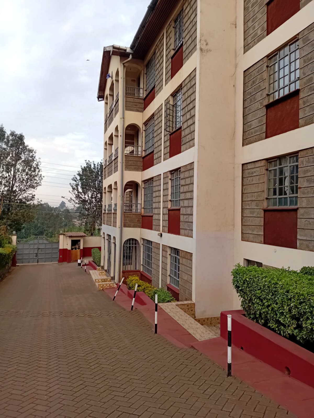 Multi-story residential building facade with red and cream trim