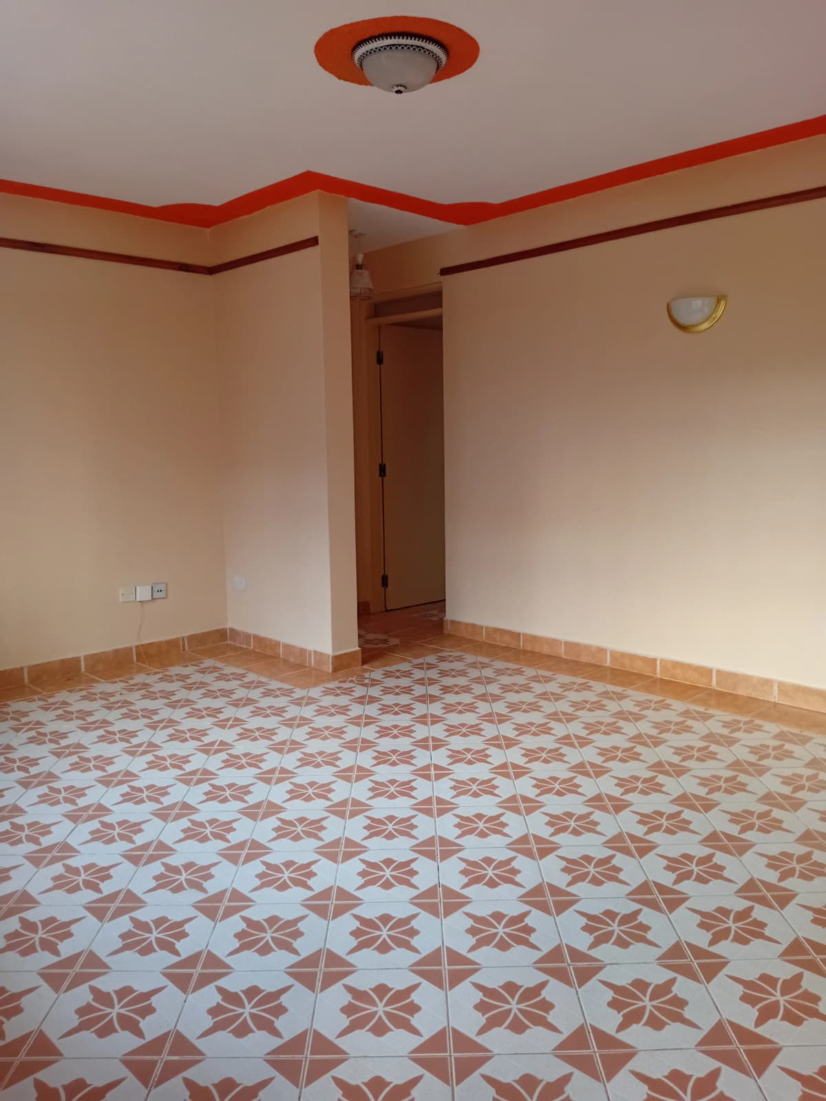 Empty bedroom with geometric tile flooring and red accent ceiling