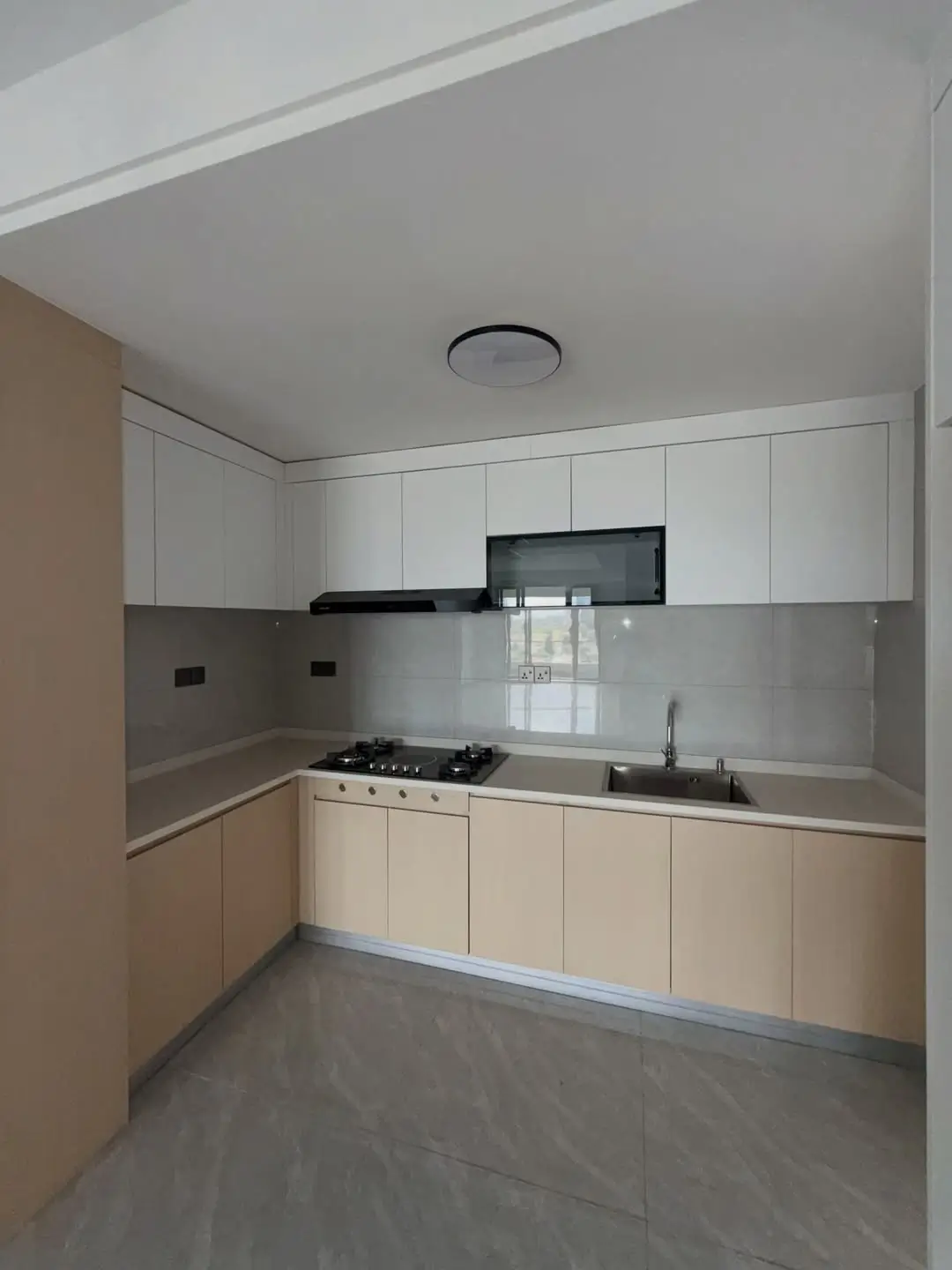 Modern kitchen with white cabinetry and gray backsplash