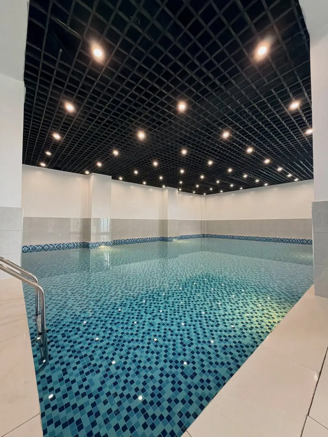 Indoor swimming pool with blue mosaic tile floor