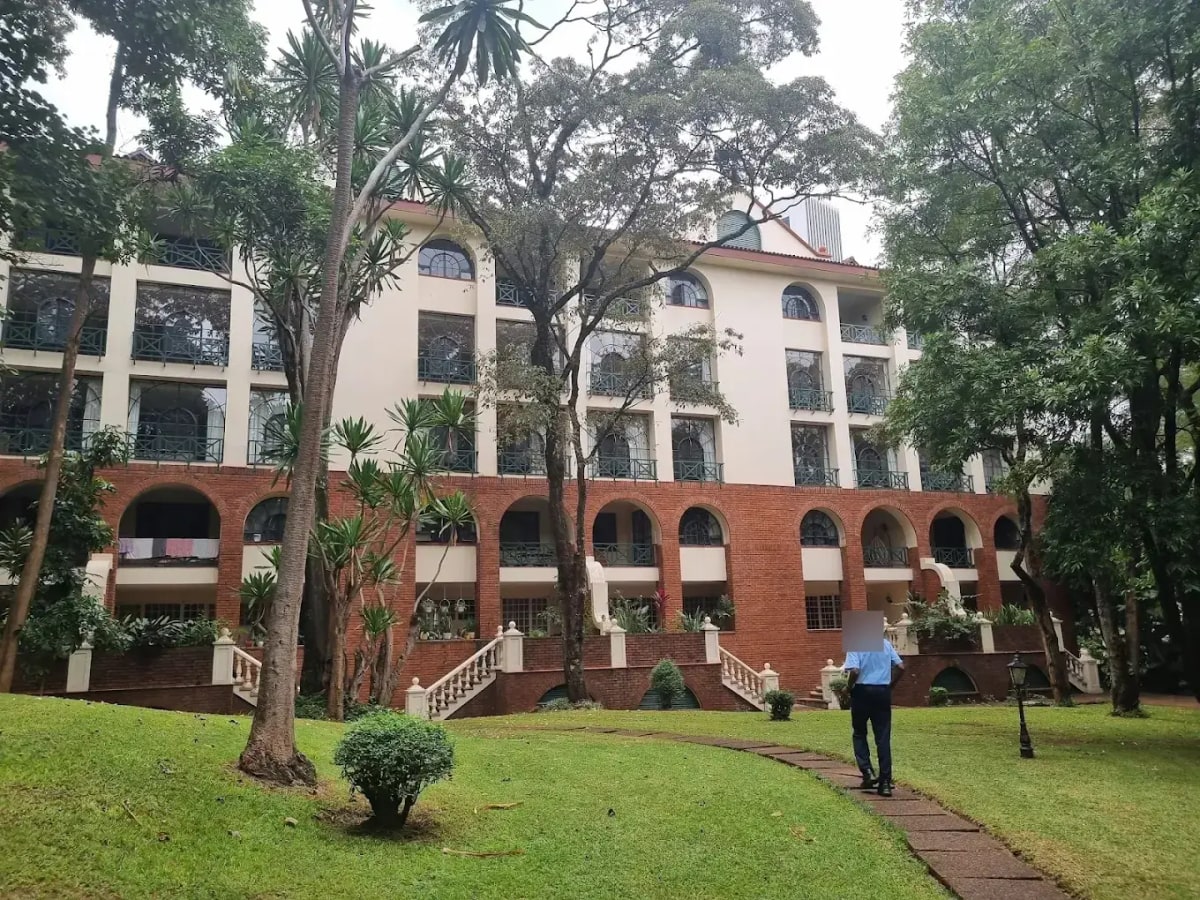 Colonial-style building facade with manicured grounds and mature trees