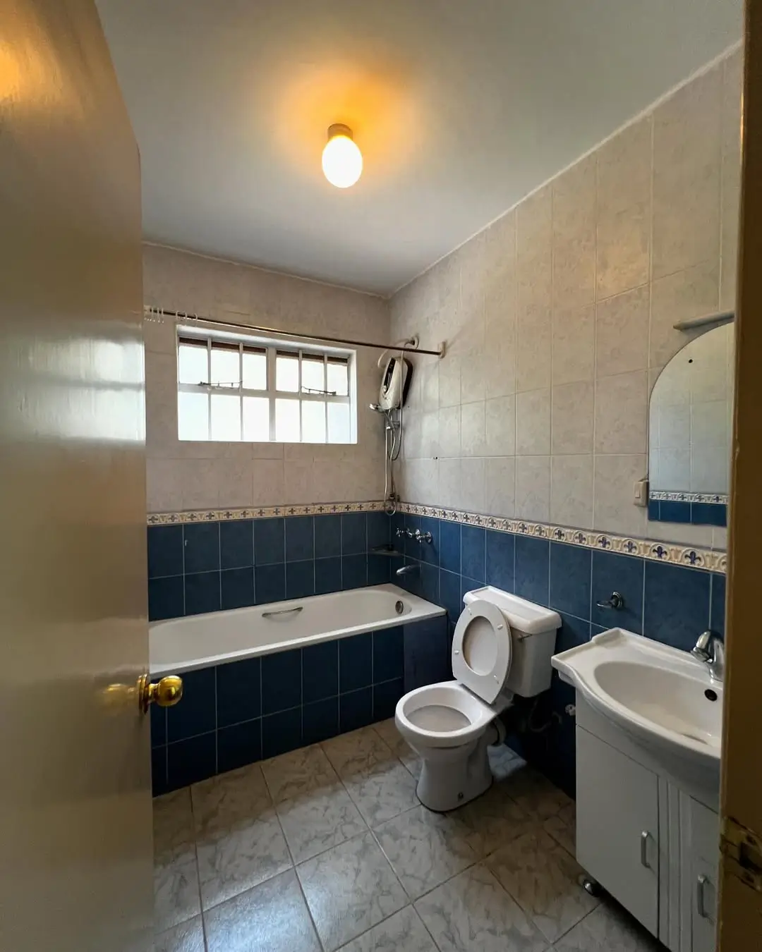 Bathroom with bathtub, toilet, sink, blue tile accents