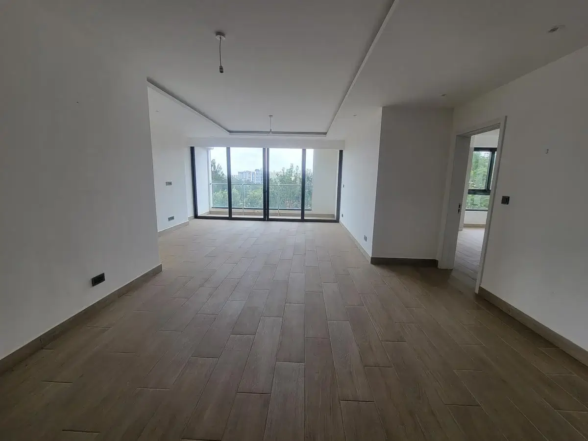 Spacious empty living room with large windows and wood flooring