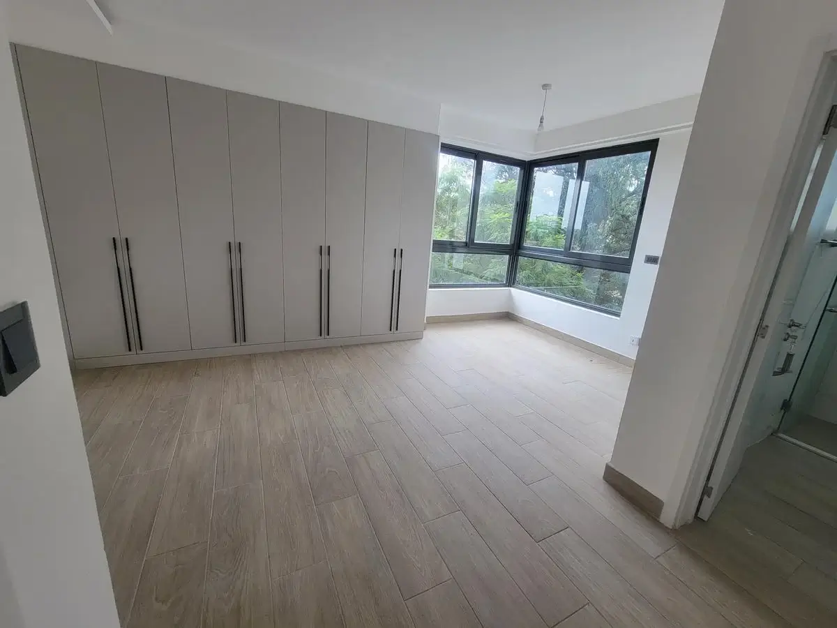 Spacious bedroom with built-in wardrobes and corner windows