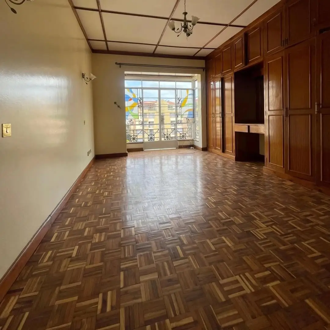 Spacious living room with herringbone floor and city view windows