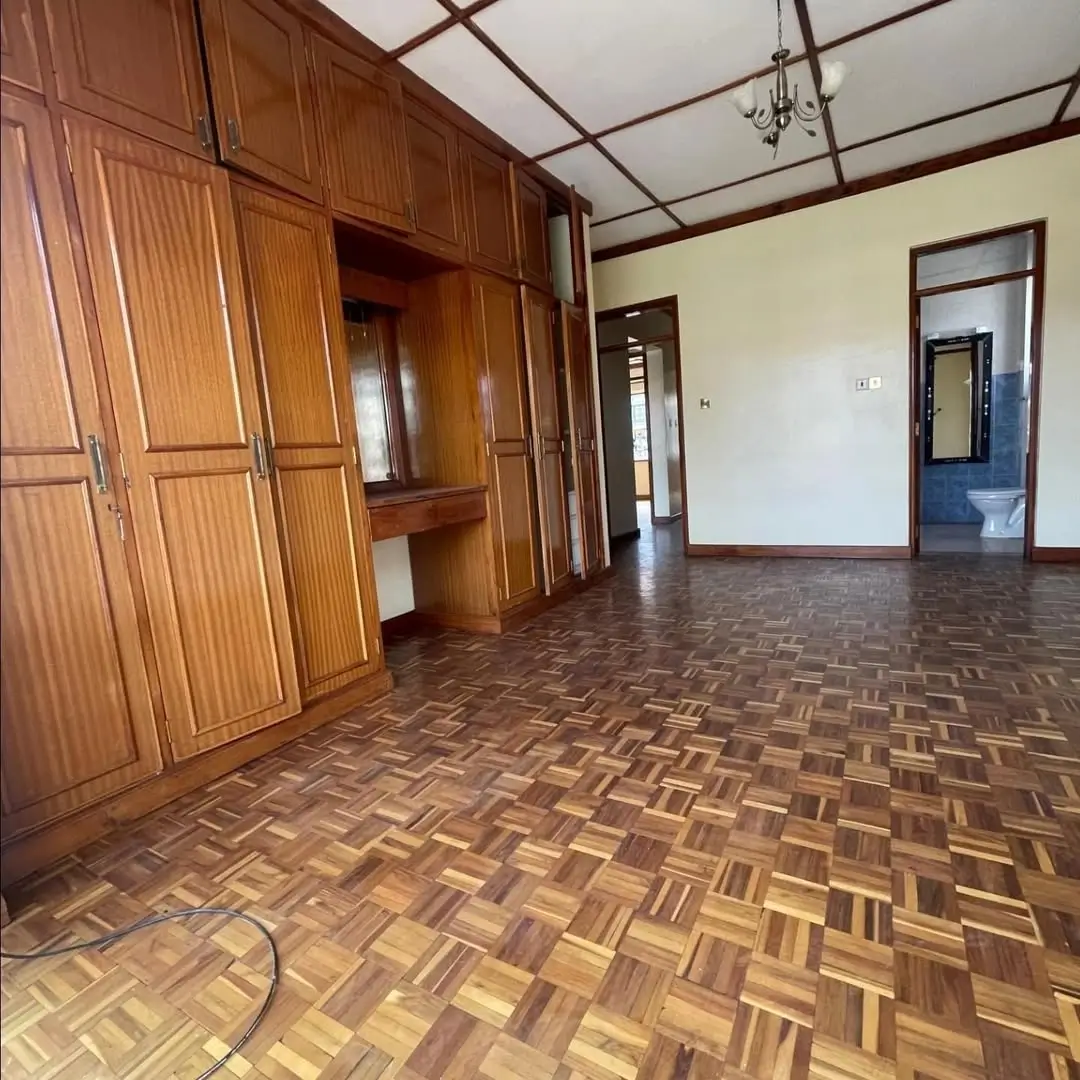 Spacious bedroom with wooden wardrobe and parquet flooring