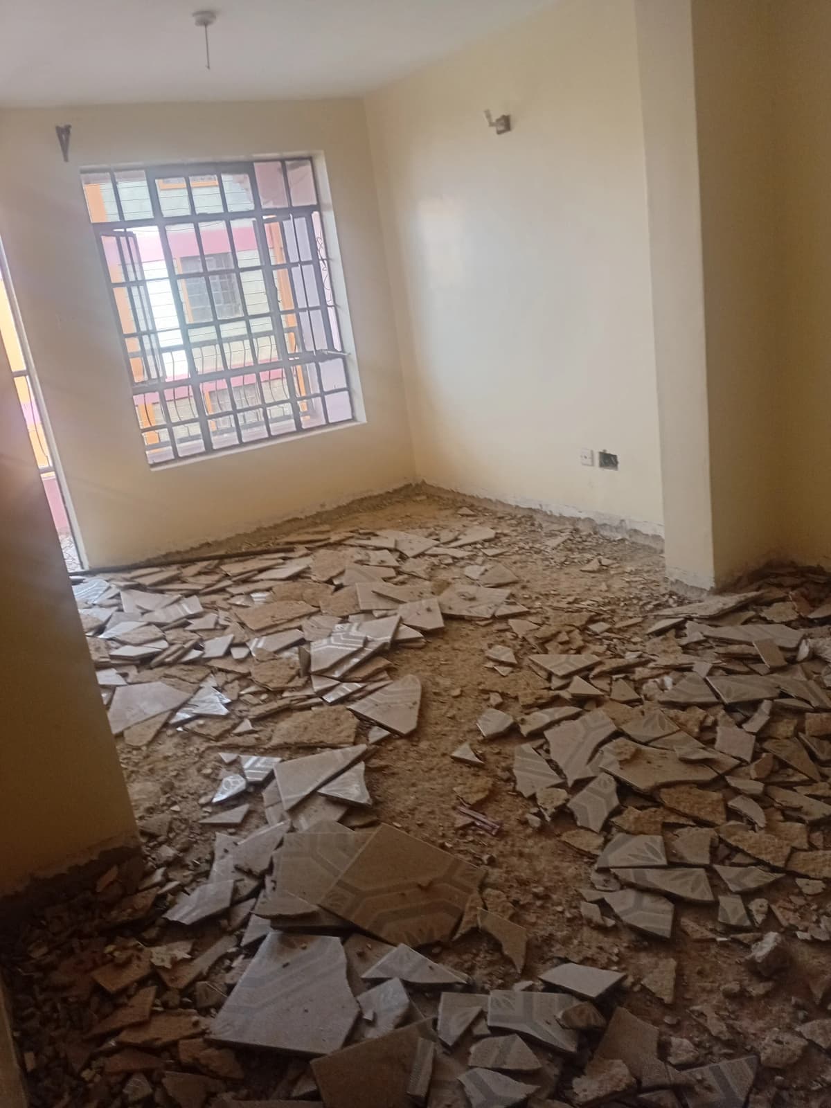 Unfurnished bedroom with barred window, under renovation