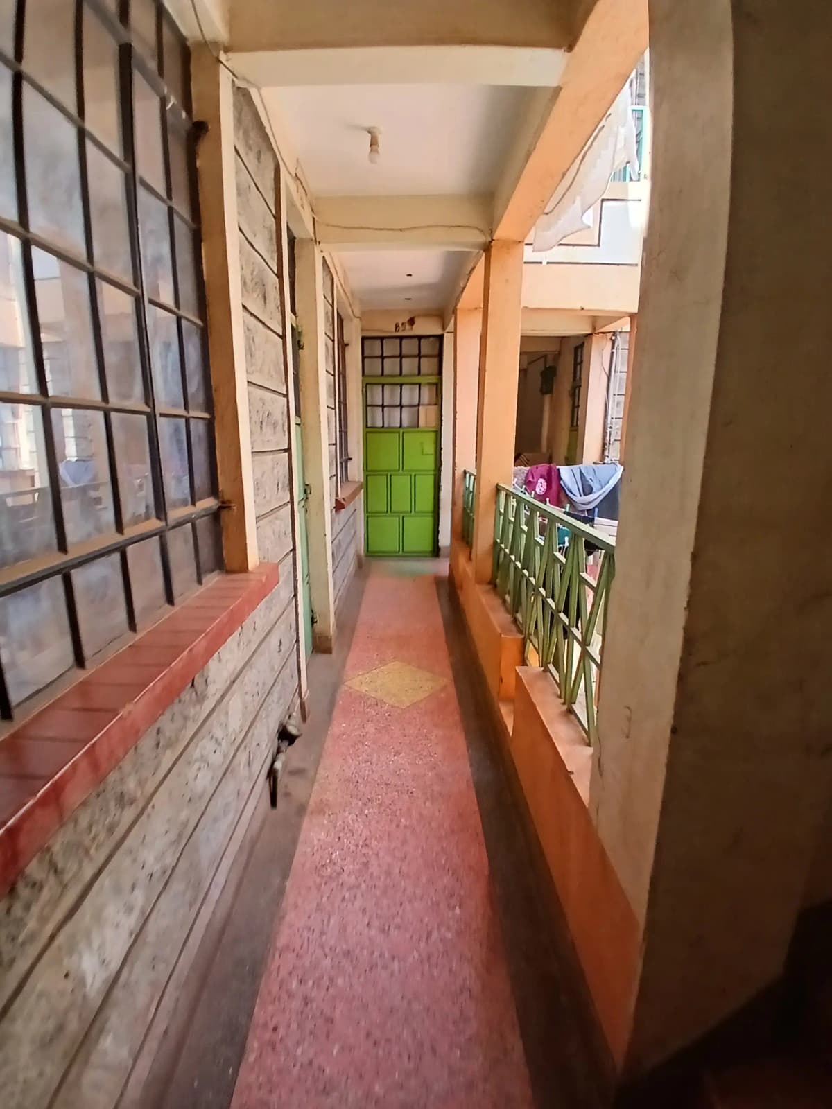 Long corridor with red carpet and bright green door