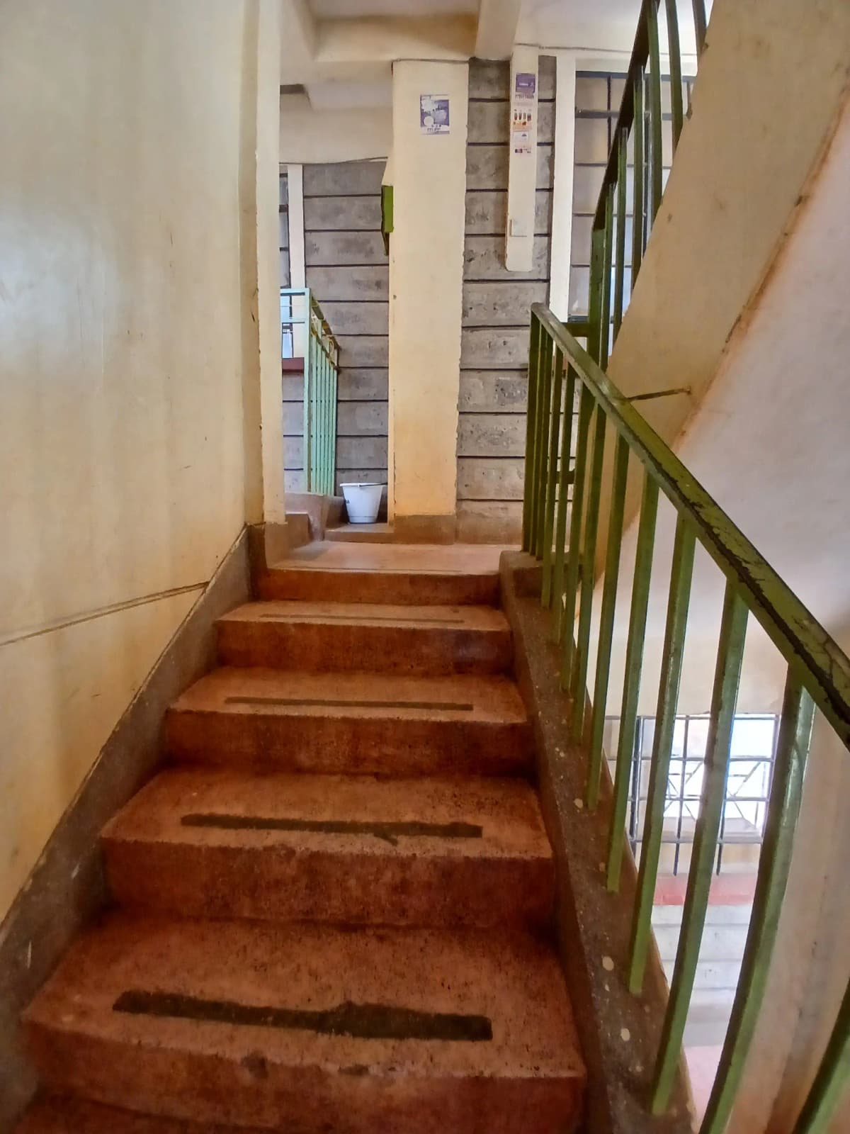 Building stairwell with metal railing and tiled landing